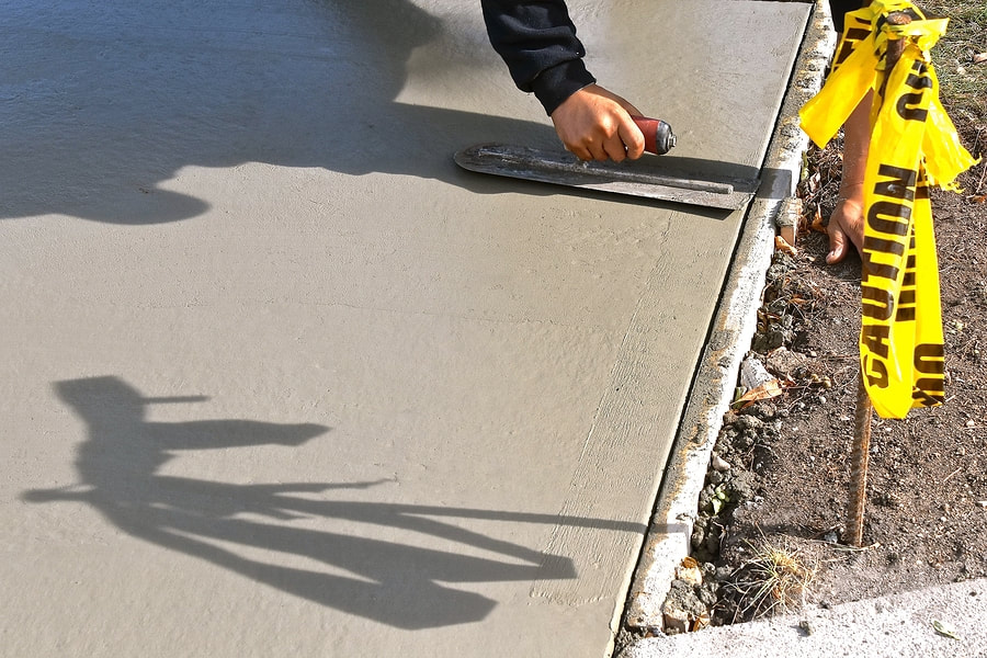 man smoothening the surface of the cement 
