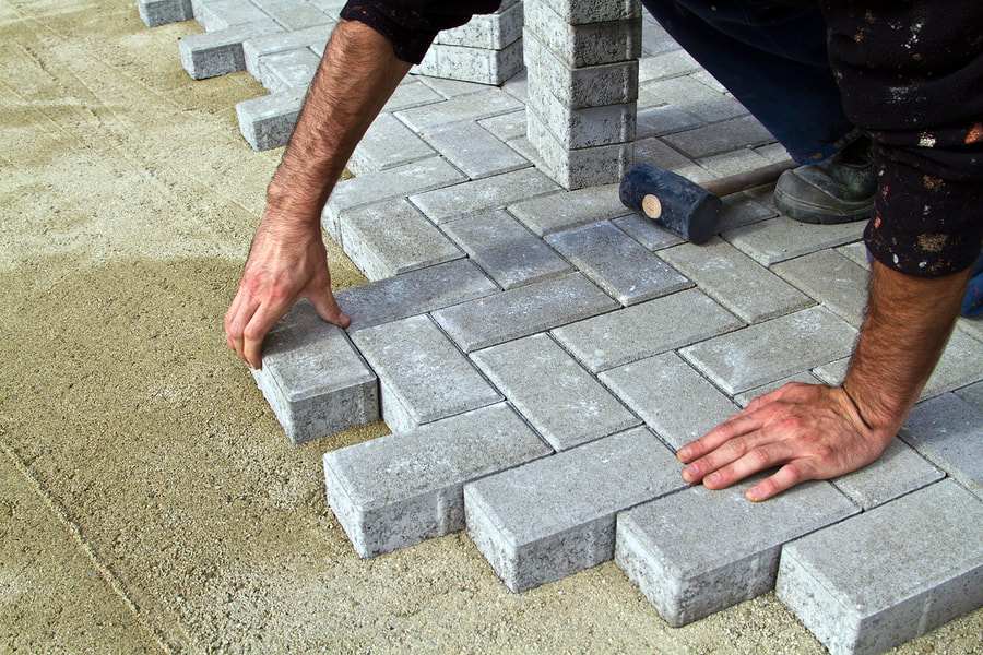 man working a brick pavement